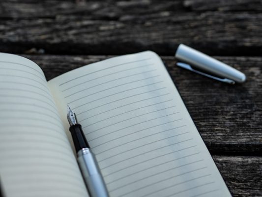 Picture of a pen and notebook ready for turning moving day into a fun event